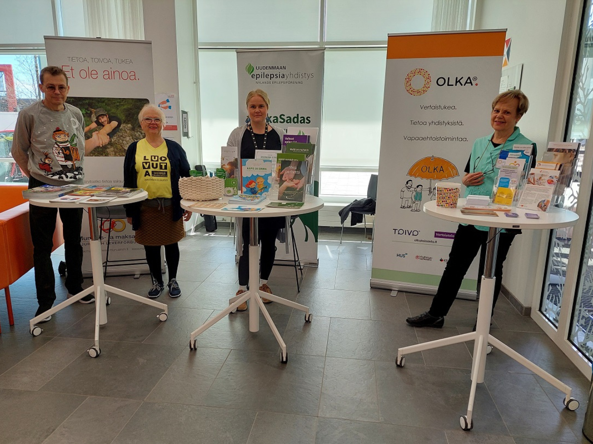 Uudenmaan munuais- ja maksayhdistys UUMU ry, Uudenmaan Epilepsiayhdistys ry sekä OLKAn vapaaehtoinen aula-avustaja esittelemässä toimintaa OLKA-pisteellä.