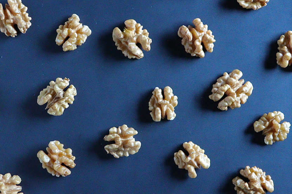 Saksanpähkinöitä aseteltuna siniselle alustalla, tasaisin välimatkoin toisistaan.